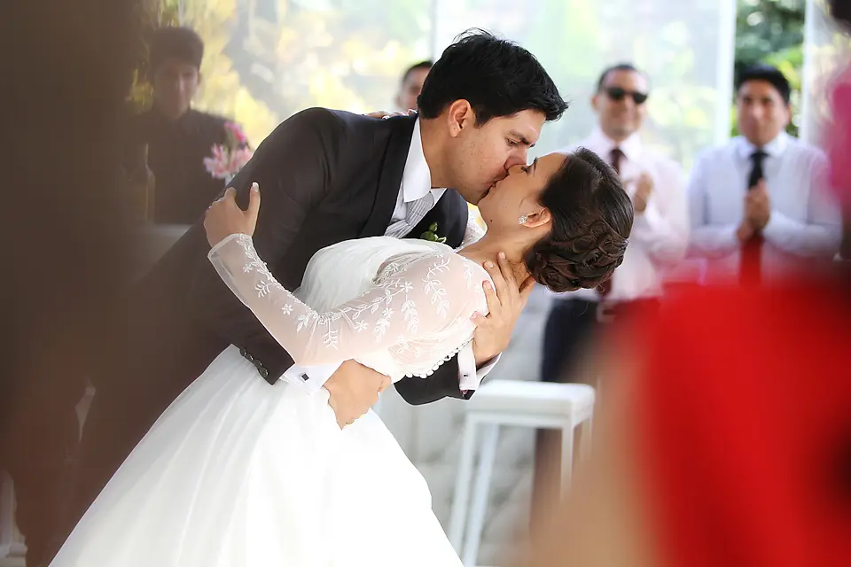 El novio inclina a la novia de manera romántica para darle un beso durante la celebración o primer baile de la recepción de bodas en chia cundinamarca