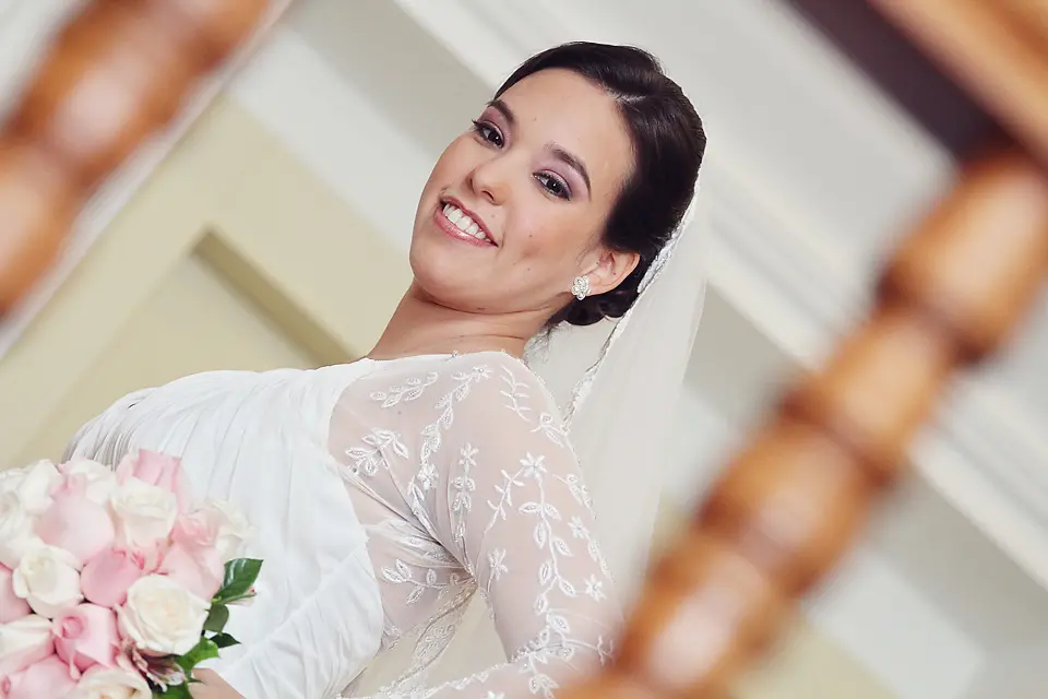 Retrato de perfil de novia luciendo vestido con mangas de encaje y sosteniendo su ramo de rosas en Chía, Cundinamarca.
